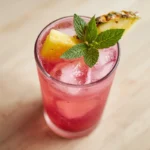Vibrant pineapple dragonfruit lemonade in a glass with fruit garnishes and ice, ready to enjoy.