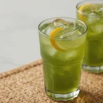 Iced matcha lemonade recipe in a tall glass with a lemon slice and ice. Refreshing green drink ready to enjoy.